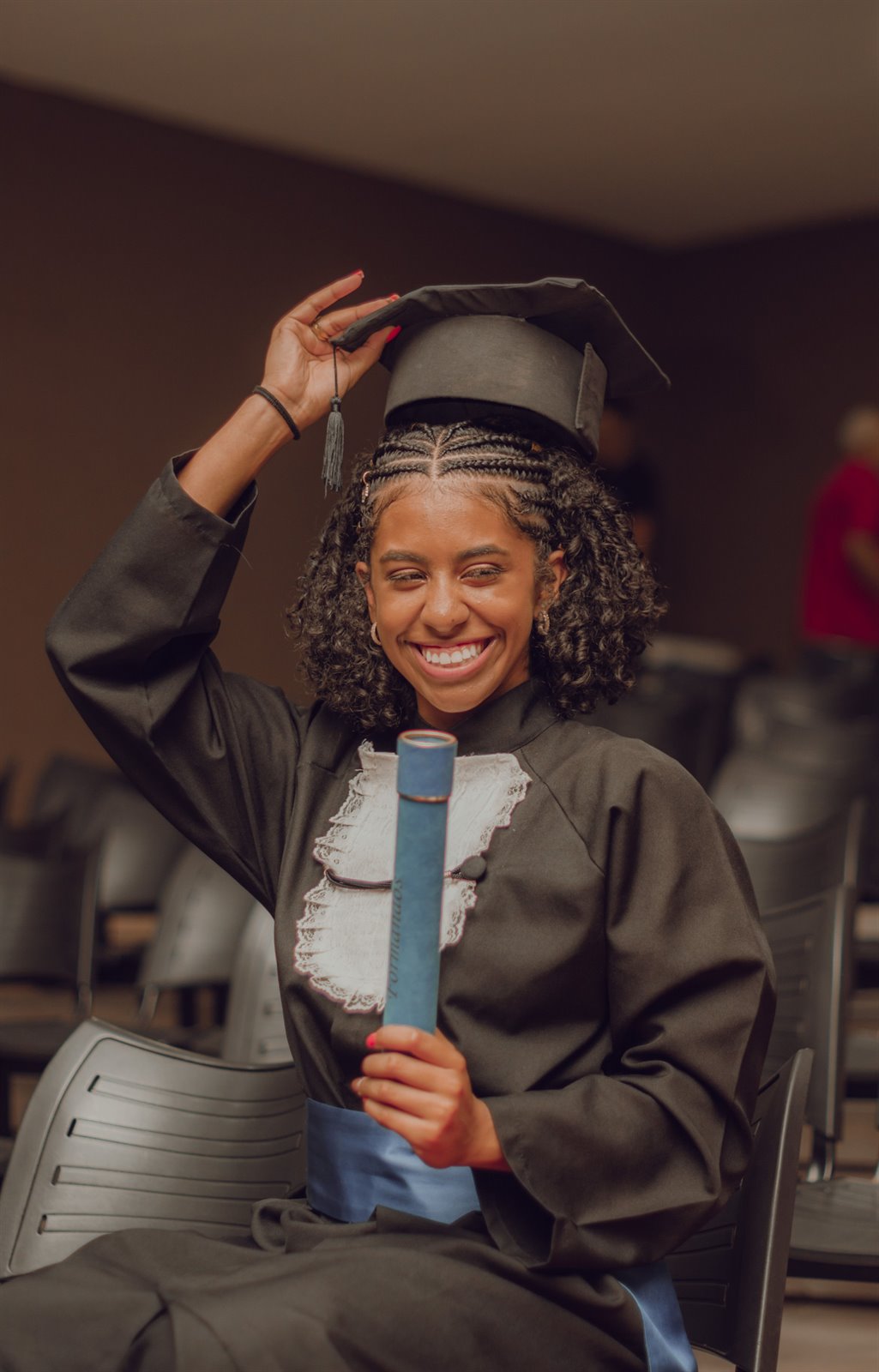 Jeune diplômée tenant son diplôme lors d’une cérémonie